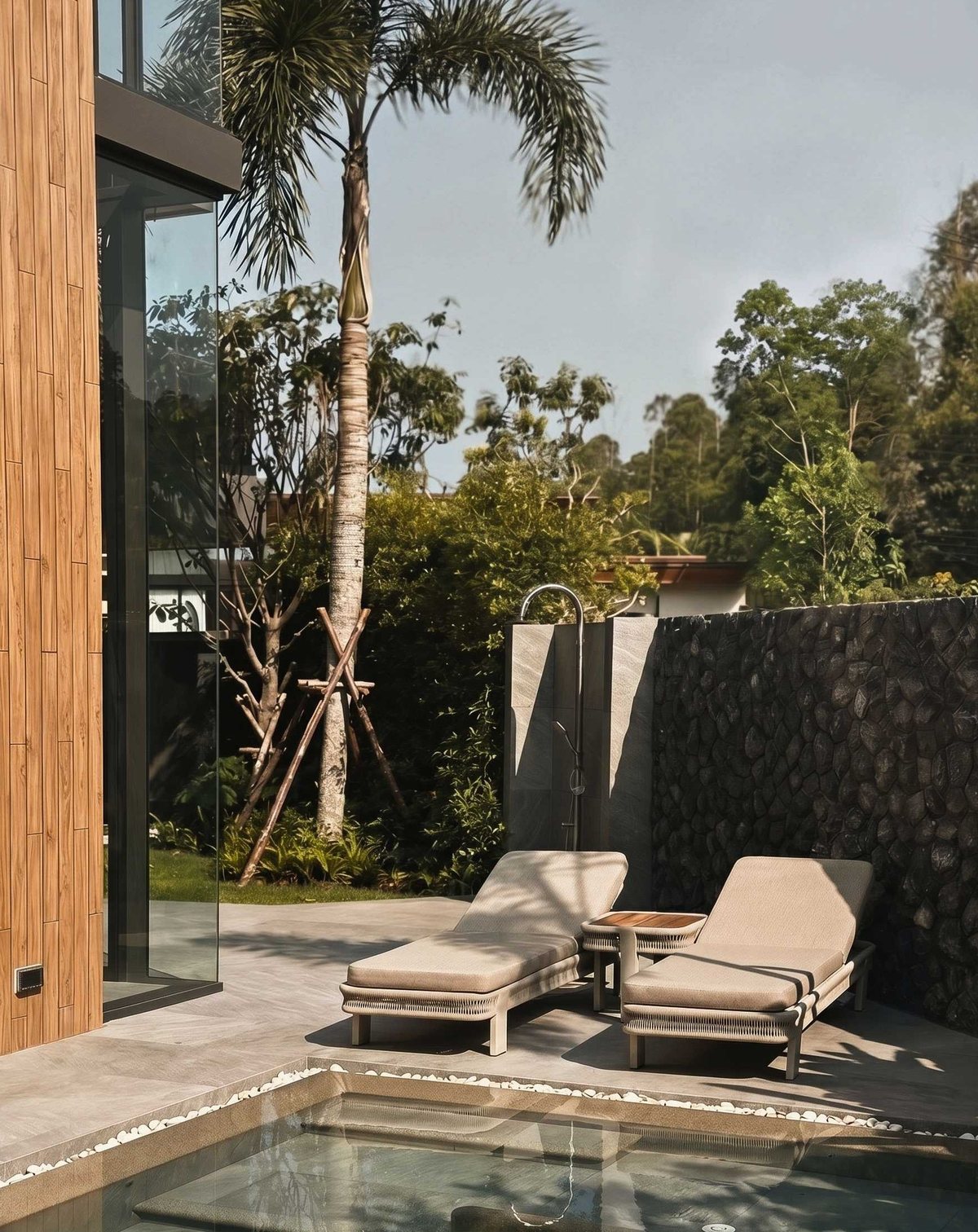 Sun loungers by a private pool next to a stone wall
