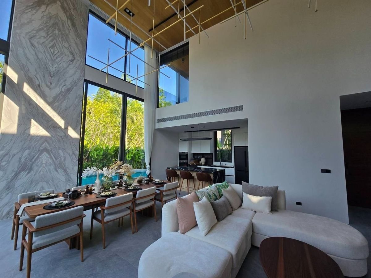 Living and dining area with a double-height ceiling in the show villa
